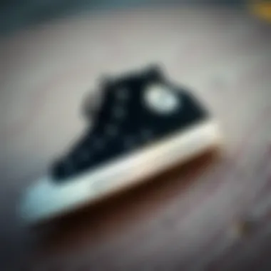 Classic black Converse Chuck Taylor shoes on a textured surface